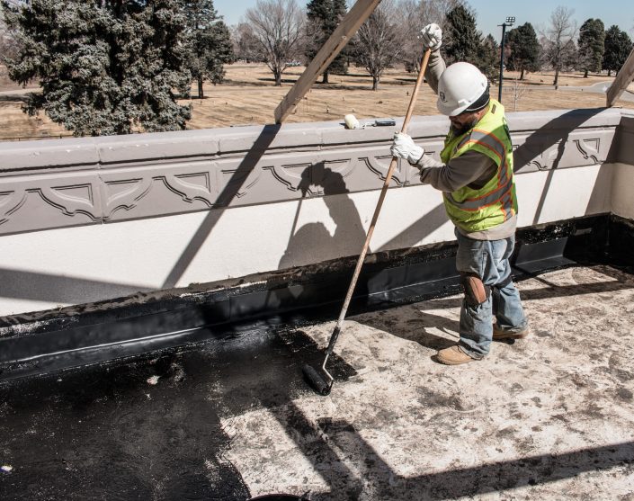 Worker applies hot applied waterproofing to a deck