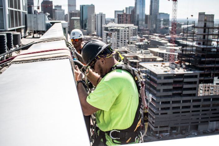 workers prepare to rappel off a building in Denver